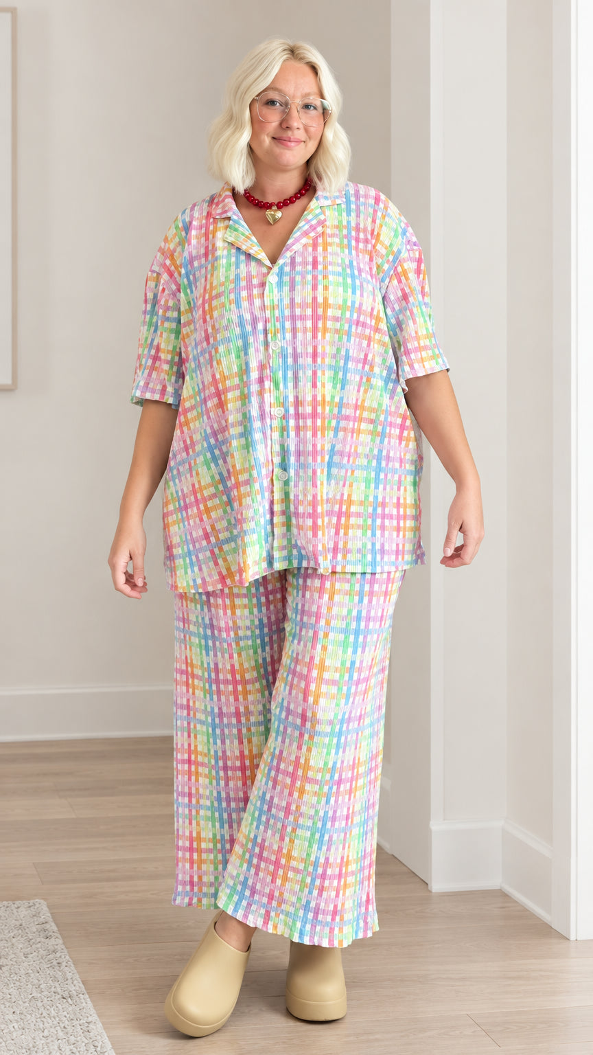 Front view of model wearing pastel rainbow plaid short sleeve shirt and wide leg pants set