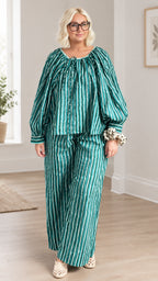 Full front view of model wearing green vertical striped two-piece top and wide-leg pants set