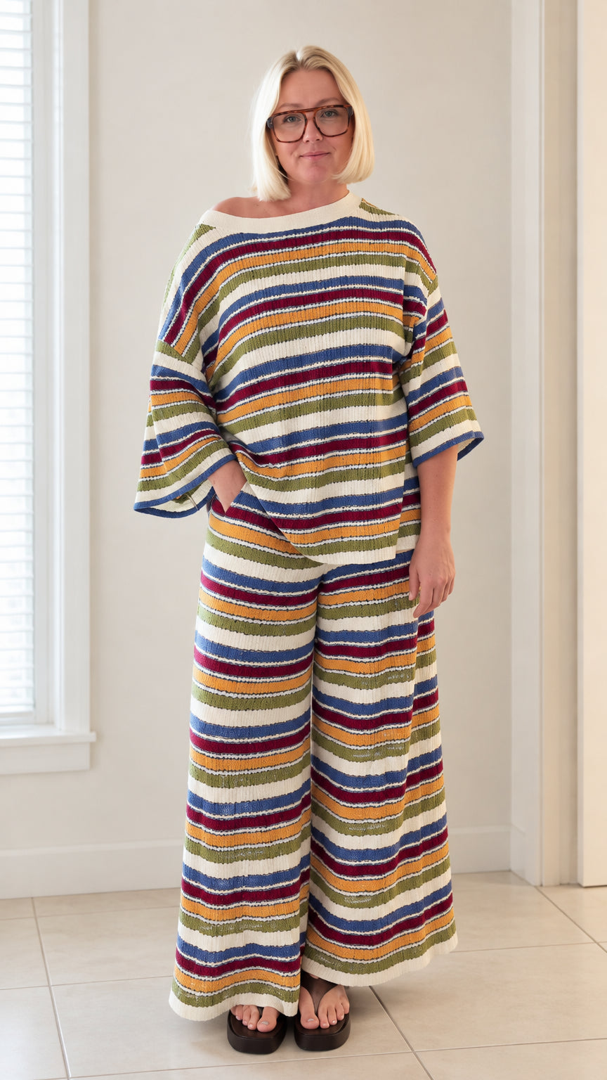 Front full view of woman wearing white multicolor striped knit top and wide leg pants set