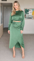 Front view of model wearing sage green satin crop top and wrap midi skirt two-piece set