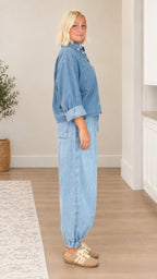 Side profile view of relaxed light blue denim two-piece pant set