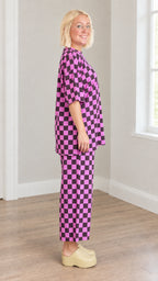 Side profile of model wearing magenta and black checkered two-piece loungewear set