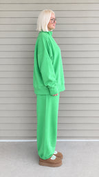 Side profile view of woman wearing bright green two-piece loungewear set