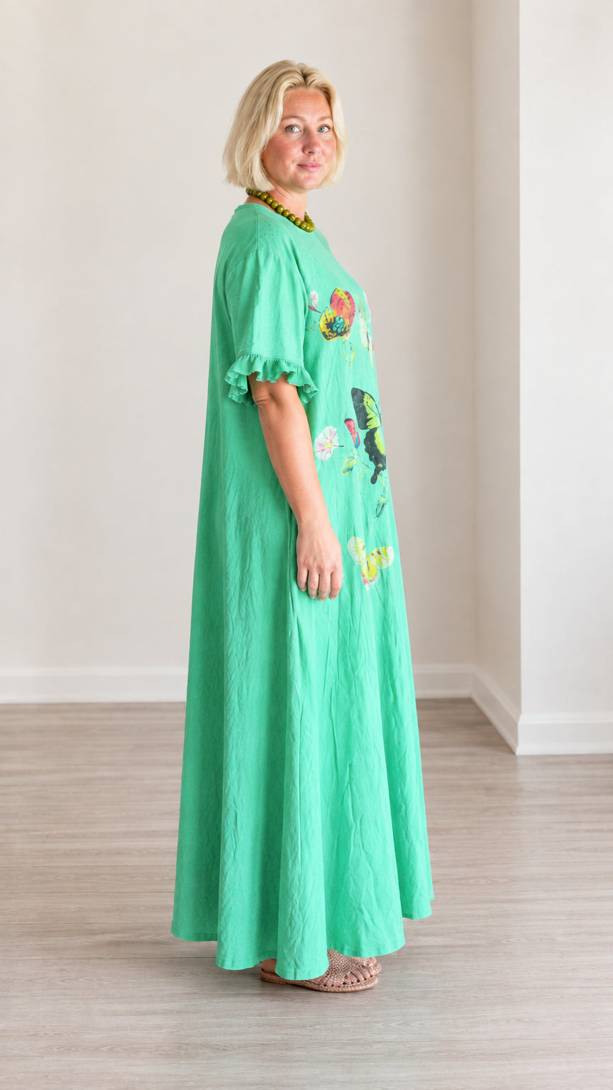 Side view of green butterfly print maxi dress showing flowing A-line silhouette
