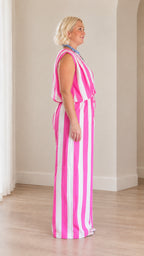 Side profile view of woman modeling pink and white striped two-piece wide leg outfit