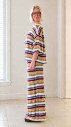 Side profile view of woman wearing white multicolor striped knit two piece set
