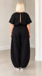 Back view of black jumpsuit highlighting the open keyhole slit cutout
