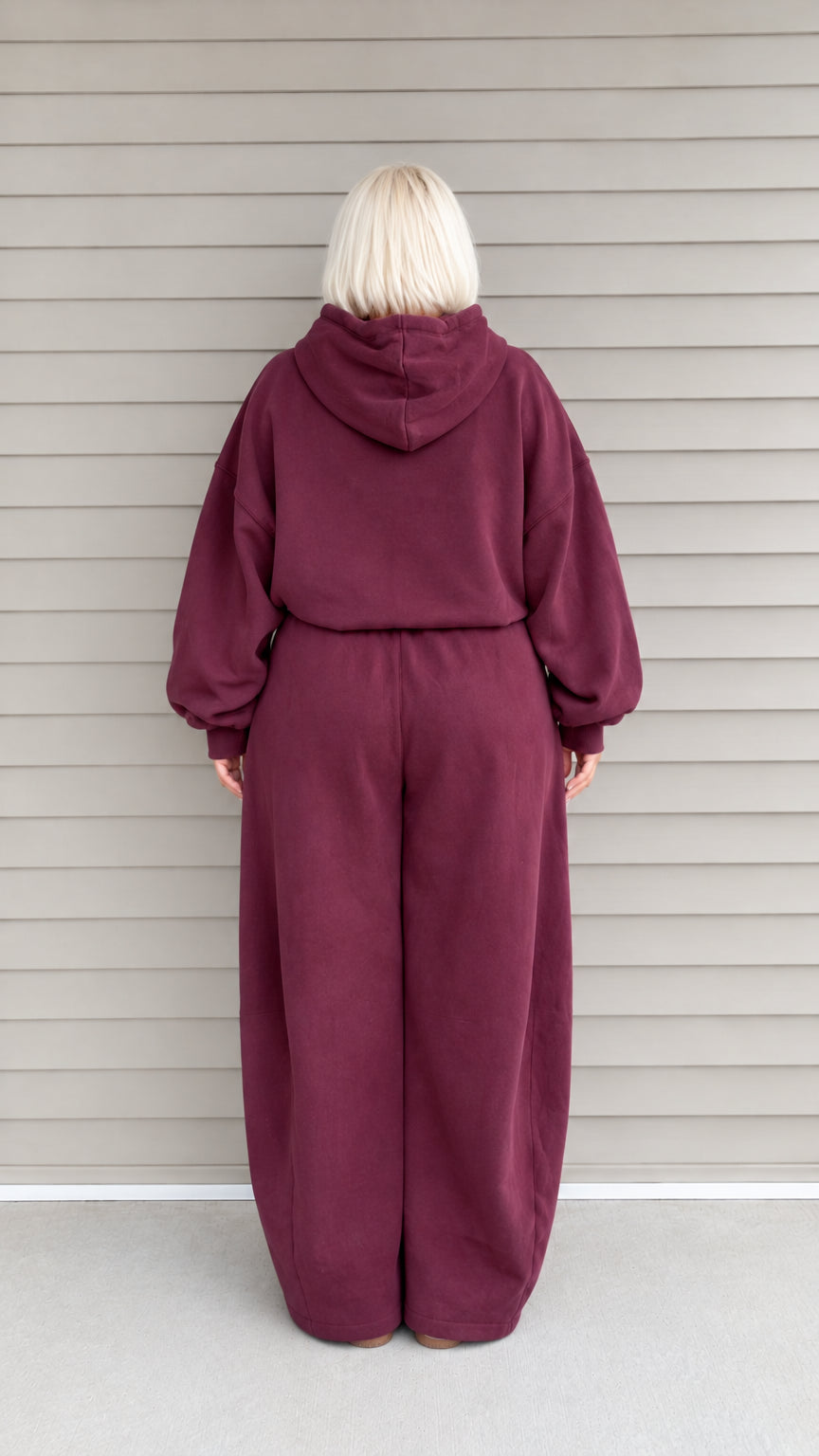 Back view of woman wearing burgundy relaxed hoodie and wide-leg sweatpants