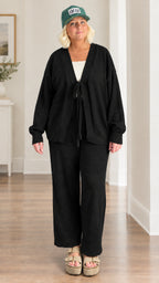 Woman wearing black 2-piece front-tie cardigan and matching wide-leg trousers