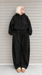 Front view of woman wearing black oversized hoodie and wide-leg sweatpants lounge set