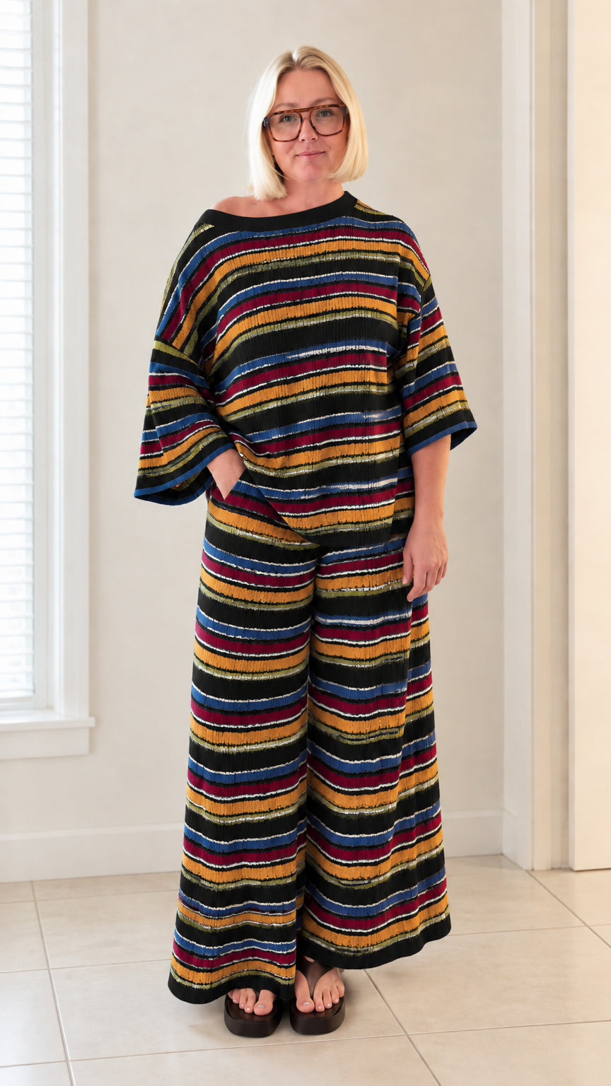 Front full view of woman wearing black multicolor striped knit top and pants set