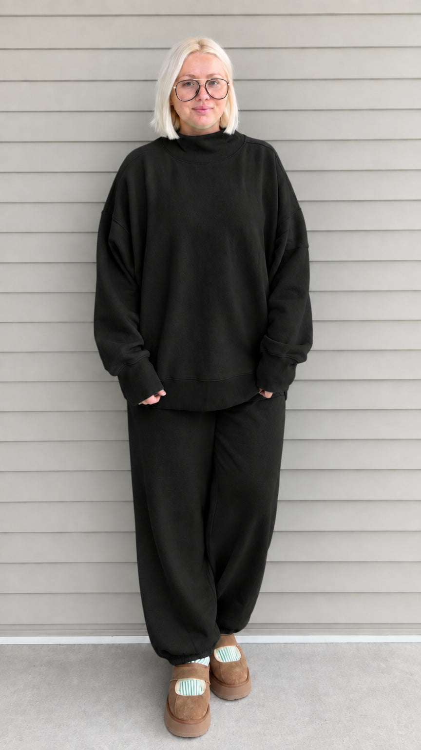 Full front view of woman wearing black oversized mock neck sweatshirt and jogger pants set