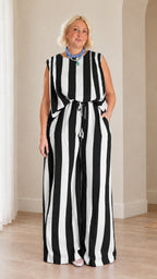 Full front view of woman wearing black and white striped sleeveless top and wide leg pants set