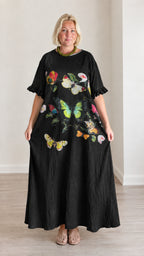 Front view of black maxi dress featuring colorful butterfly and flower graphic