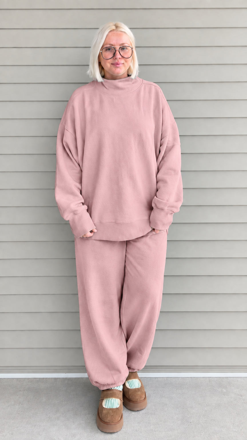 Full front view of woman wearing dusty pink oversized mock neck sweatshirt and jogger pants set