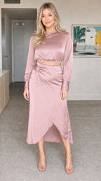 Model wearing dusty rose satin long sleeve crop top and midi skirt set