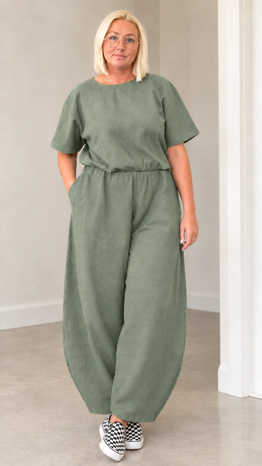 Front view of woman wearing sage green casual lantern jumpsuit