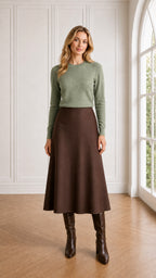 Model wearing sage green textured knit pullover with brown skirt