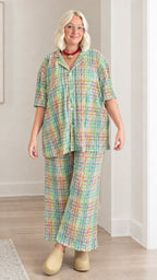 Model wearing green multicolor plaid short sleeve shirt and wide-leg trousers set
