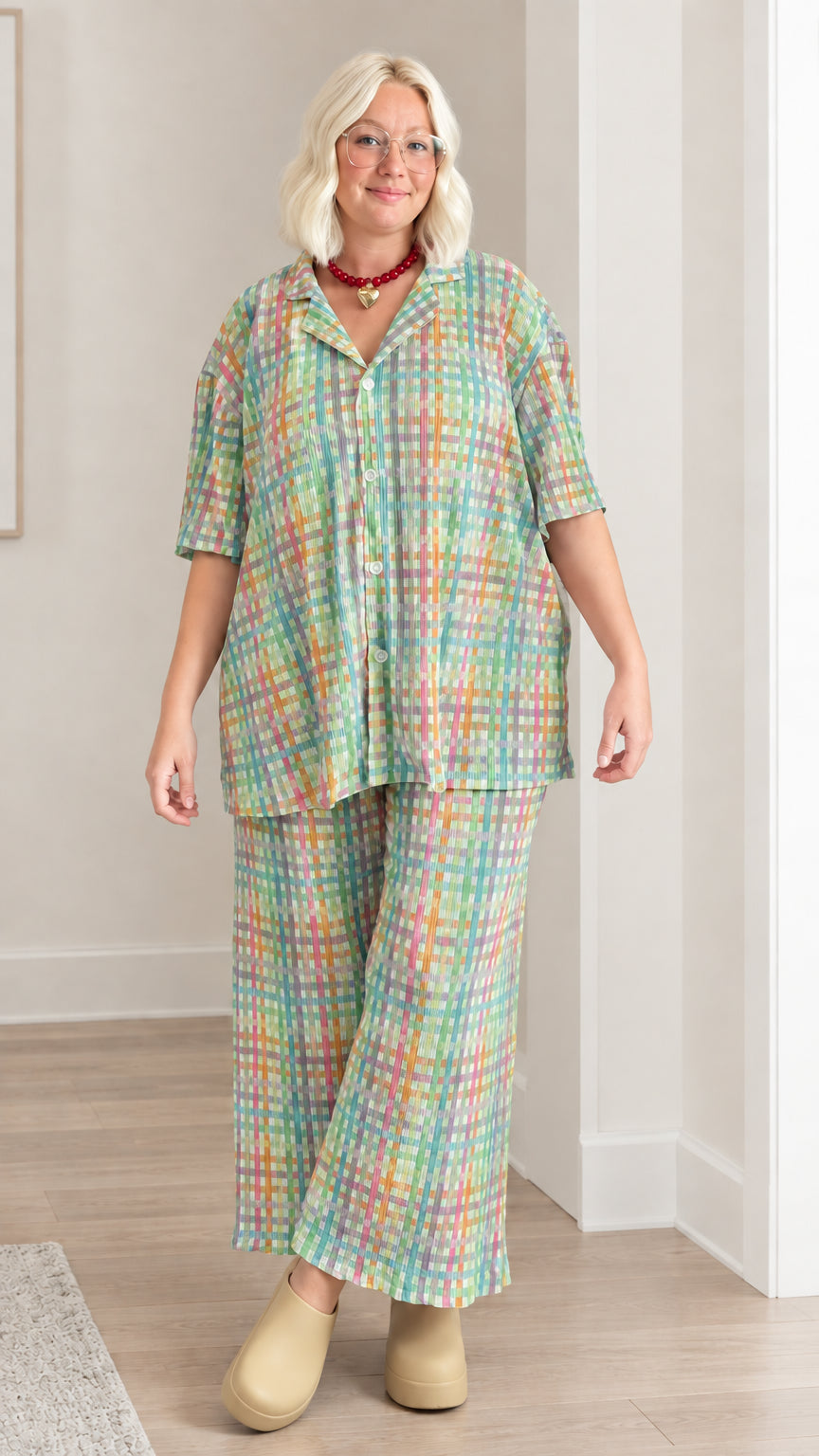 Model wearing green multicolor plaid short sleeve shirt and wide-leg trousers set