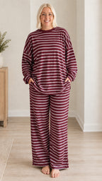 Front view of woman wearing burgundy striped long sleeve top and wide leg pants set