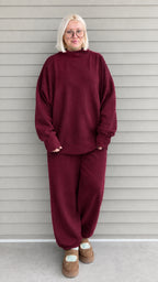 Full front view of woman wearing burgundy oversized mock neck sweatshirt and jogger pants set