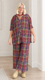 Model wearing burgundy multicolor plaid textured shirt and matching pants set