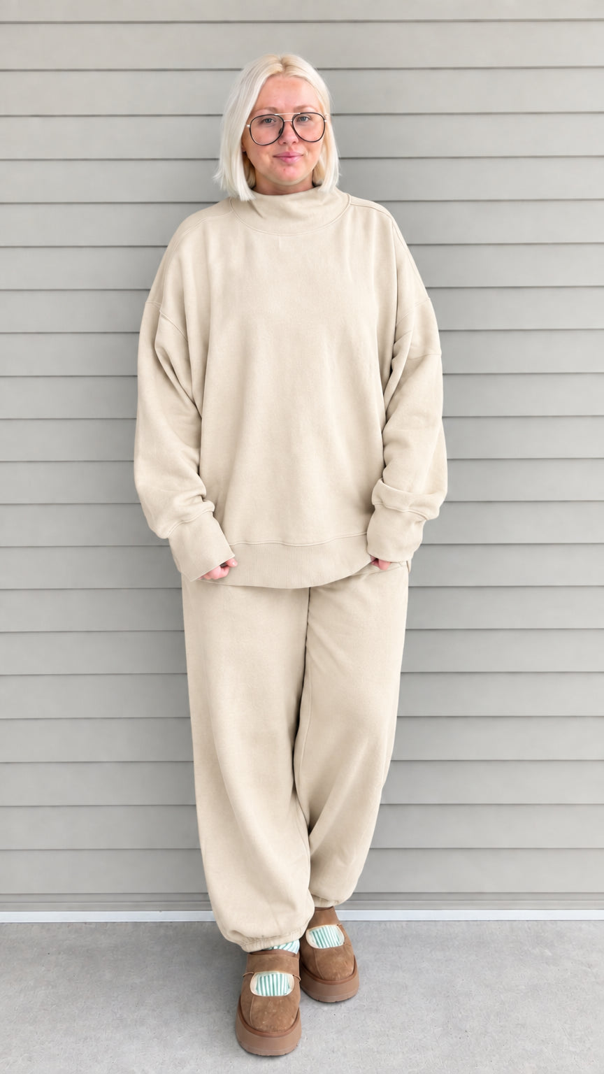 Full front view of woman wearing beige oversized mock neck sweatshirt and jogger pants set