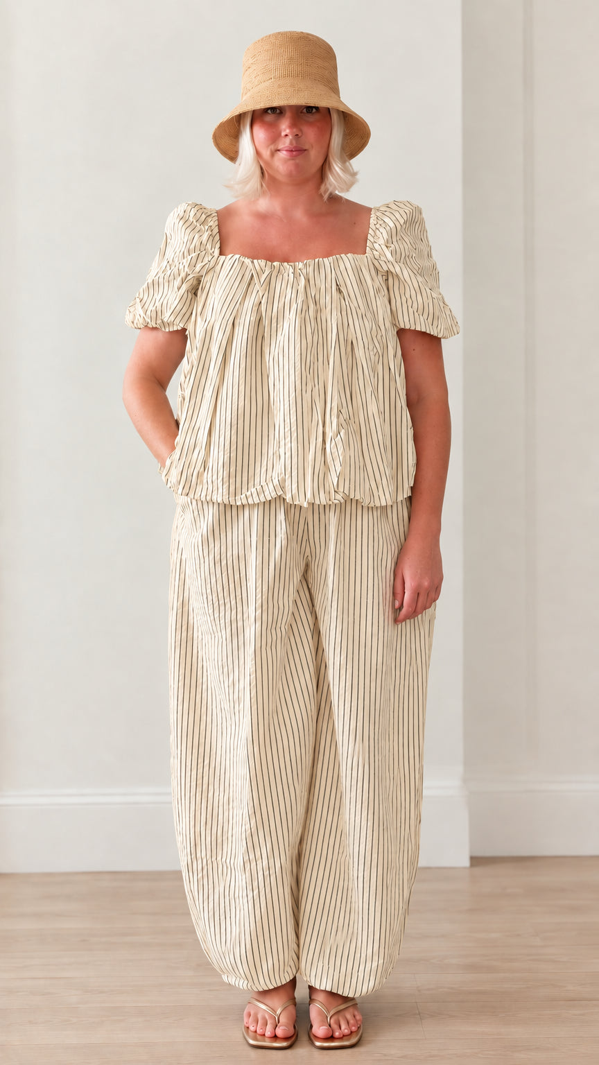 Woman wearing beige striped square neck puff sleeve top and matching lantern pants set