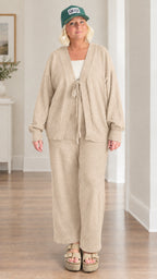 Woman wearing beige knit tie-front cardigan and matching wide-leg trousers
